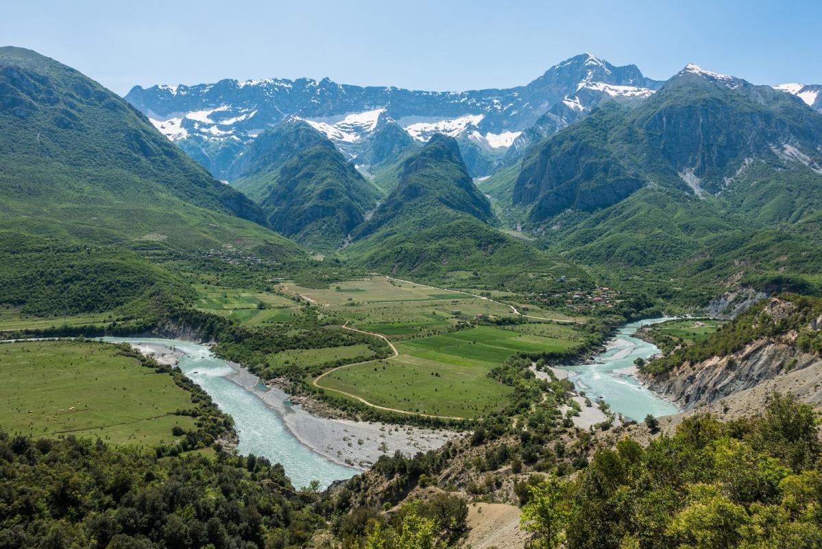 Alpine river winding through a green valley below the Albanian Alps